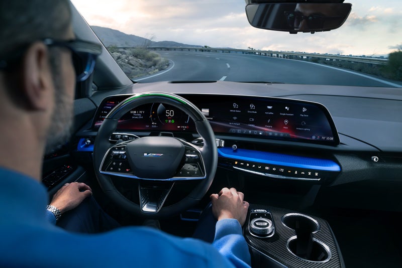 Front View of the 2026 OPTIQ-V Driving Through the Dusk Utilizing its Headlights | Sheehan Cadillac in Pompano Beach FL