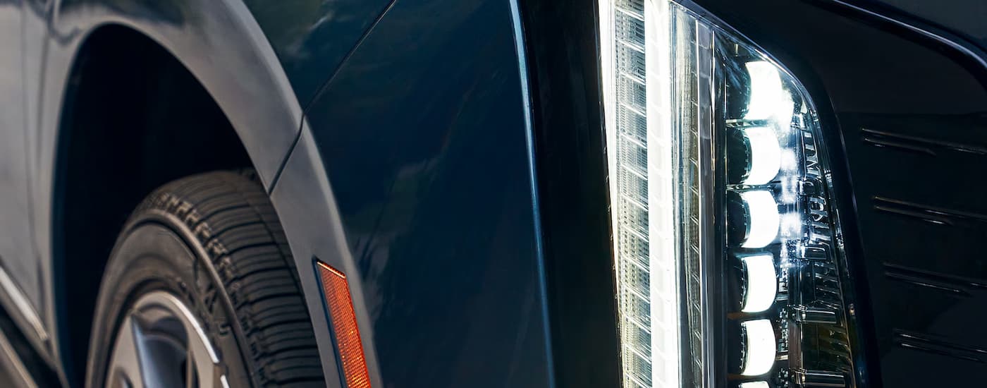 Close-up on the headlight of a blue 2026 Cadillac Escalade.