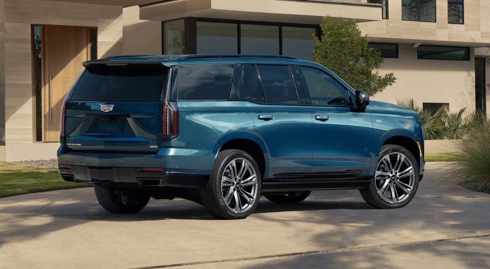Teal 2026 Cadillac Escalade parked in front of a house