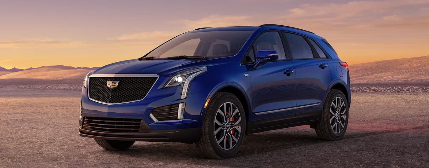 Side of a blue 2026 Cadillac XT6 parked off-road.