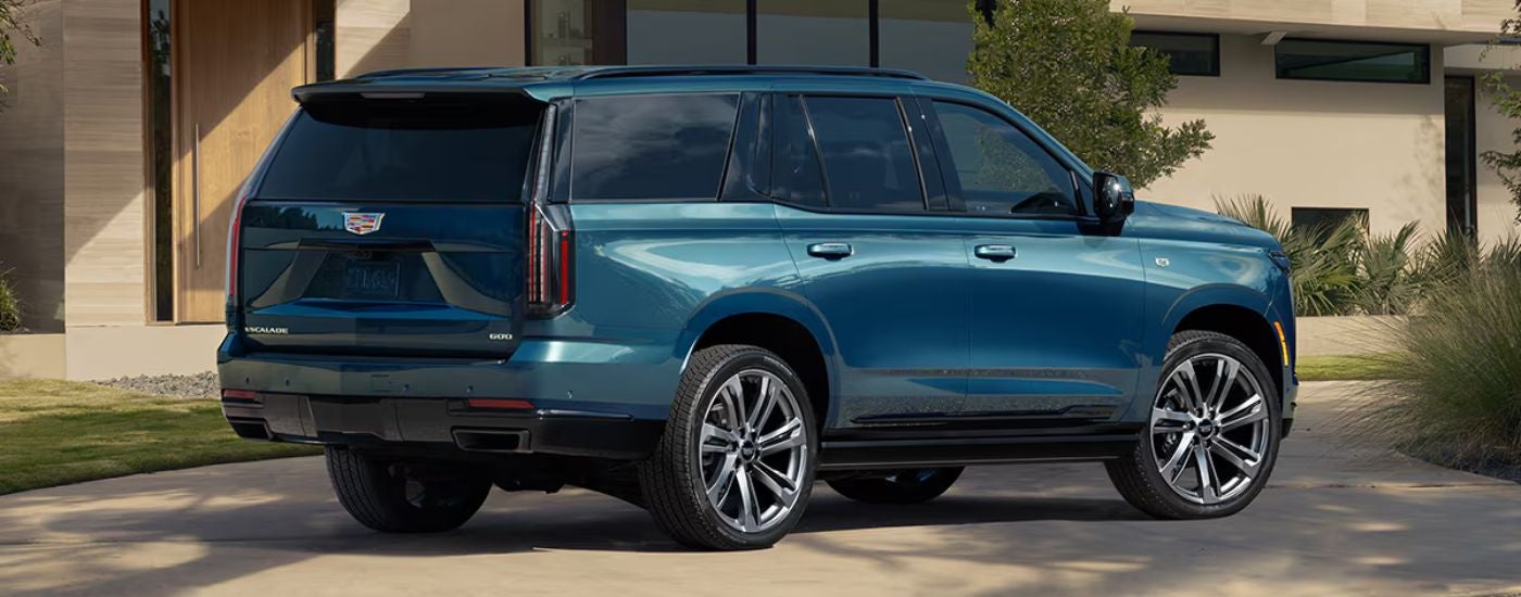Blue 2026 Cadillac Escalade from the side while parked in a driveway.