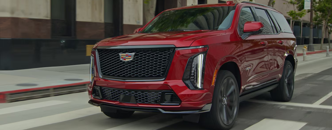 Red 2026 Cadillac Escalade driving through a city