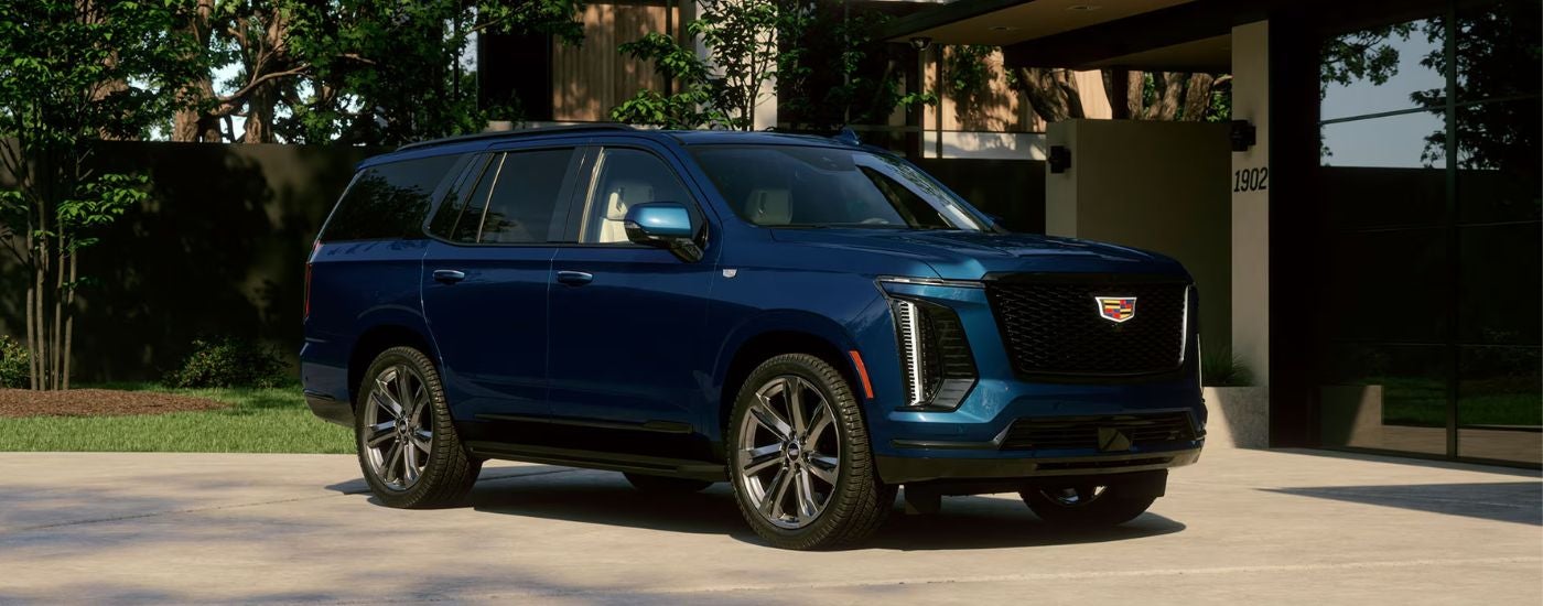 A blue 2027 Cadillac Escalade parked in a driveway.