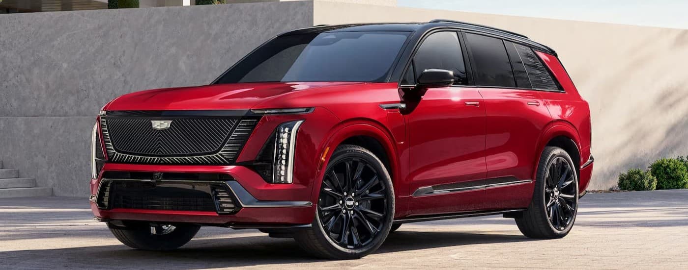 A red 2026 Cadillac VISTIQ parked on a driveway.