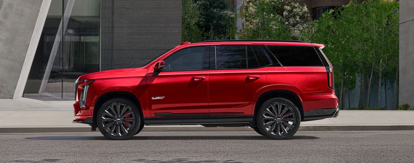 Side view of a red 2027 Cadillac Escalade parked.