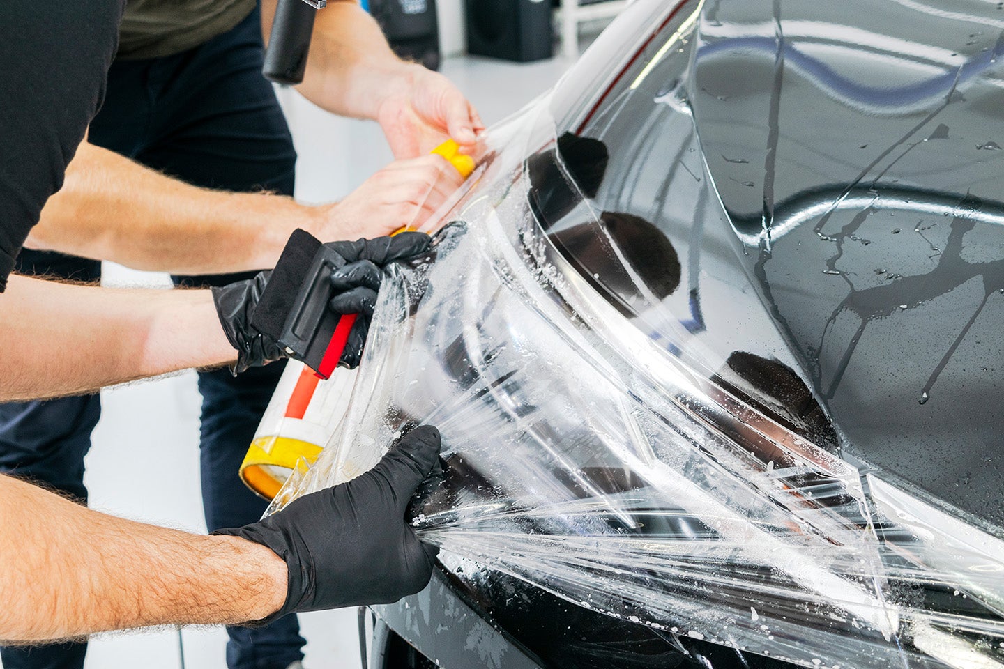 Car protective film being applied to front bumper and headlight.